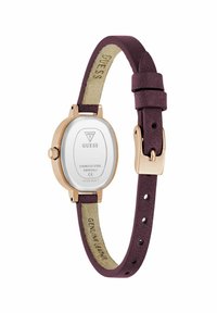 Montre en acier inoxydable rose gold avec un cadran ovale, bracelet en cuir véritable violet et finition texturée. L'arrière affiche le logo de la marque et des détails.
