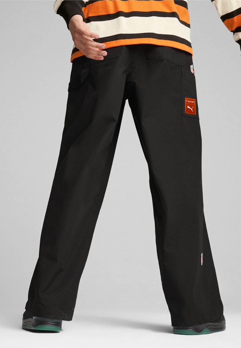 Black wide-leg pants made of durable fabric, featuring cargo pockets and a patch label. The design includes contrast stitching and a stitched logo.