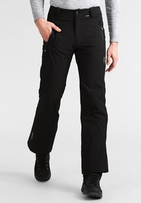 Mustat lumihousut suoran lahje muotoilulla, vetoketjulliset taskut ja kestävä kangaspinta. Suunniteltu kylmiin sääolosuhteisiin.