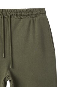 Pantaloni sportivi verde oliva con vita elasticizzata, dotati di stringhe e tasche laterali. Tessuto morbido e design dal taglio rilassato.