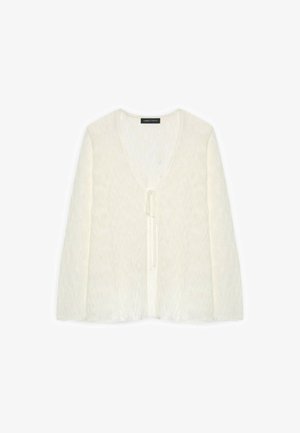 Cardigan crème à manches longues avec col en V et fermeture nouée devant, tissu léger, posé à plat sur fond blanc.