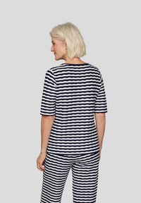 Gestreiftes Baumwolloberteil mit kurzenÄrmeln, das navy und weiße horizontale Streifen aufweist. Der Rücken ist abgerundet und das Modell hat einen lässigen Schnitt.