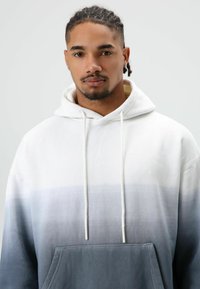 Hoodie met een verloopdesign, van wit naar grijs. Voorzien van een zak aan de voorkant en trekkoorden; zachte stoftextuur.