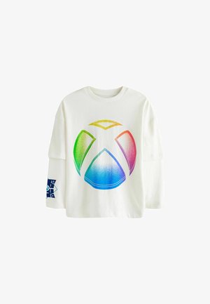 Balts pārpadārts T-krekls ar lielu varavīksnes gradienta Xbox logo uz priekšpuses un zilu dizainu kreisajā piedurknē. Mīksta kokvilnas audums.