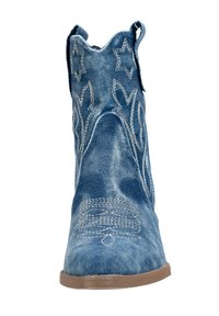 Bota vaquera de mezclilla con patrones bordados en blanco, punta afilada, caña alta y tiradores a los lados; color azul claro a medio.