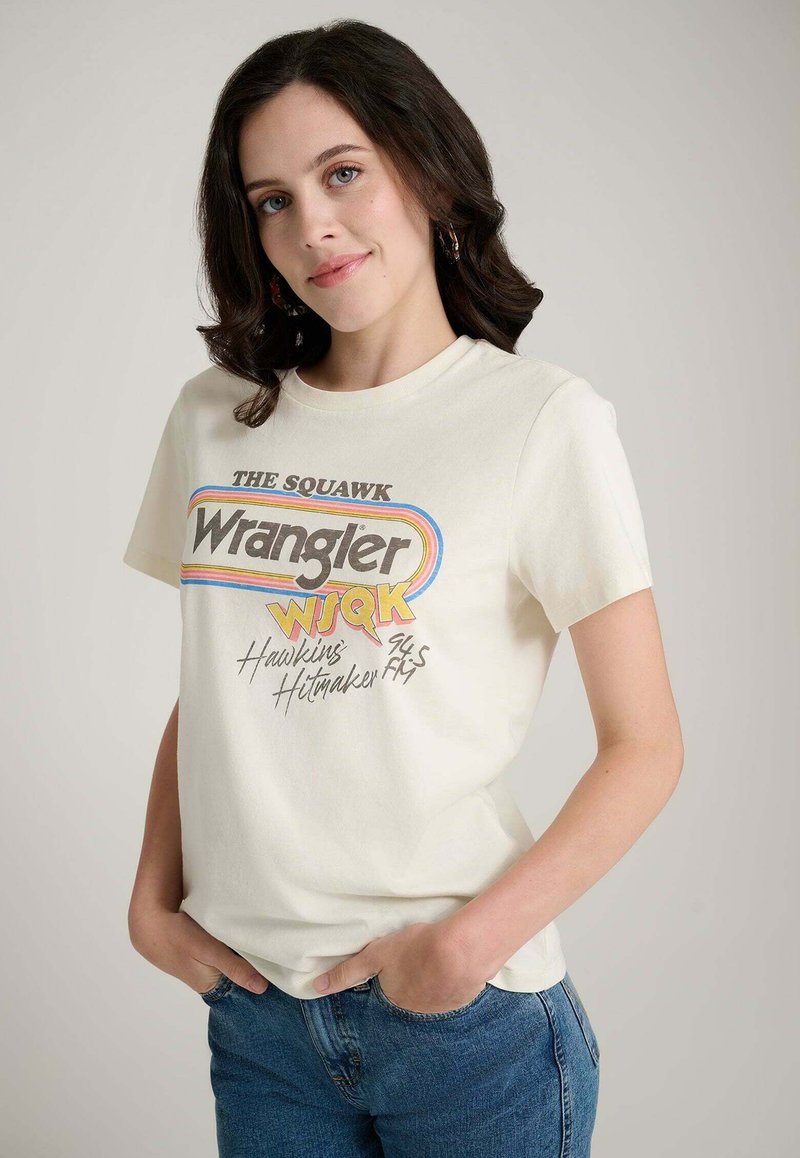 Cremefarbenes T-Shirt aus Baumwolle mit retrofarbenem Grafikdruck in verschiedenen Farben, kurzen Ärmeln und rundem Halsausschnitt.