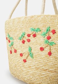 Borsa a tracolla in paglia intrecciata con manici intrecciati, decorata con bacche rosse ricamate e foglie verdi sul davanti.
