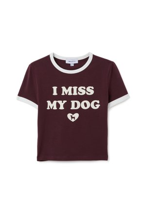 Camiseta de manga corta color burdeos con ribete blanco y el texto "MI FALTA MI PERRO" sobre un pequeño corazón con la silueta de un perro.