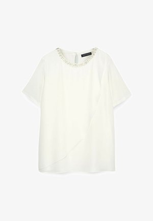 Biała bluzka z krótkim rękawem i okrągłym dekoltem, ozdobiona koralikami. Posiada drapowaną pracę z przodu oraz ukryty zamek z tyłu.