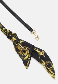 Cintura in pelle nera con una sciarpa in seta a motivo giallo e nero attaccata, dotata di una chiusura in metallo color oro e dettagli accentati.