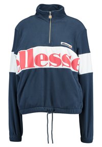 Fleece-pull med hög krage, marinblå kropp, vita och röda horisontella ränder, halvdragkedja framtill och justerbar dragsko i nederkant.