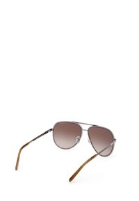 Gafas de sol aviador metálicas con lentes marrón degradado, montura plateada y detalles texturizados en los lados. Puntas de las patillas tintadas de marrón para mayor comodidad.