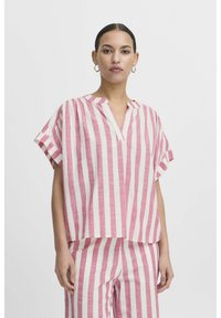 Top a maniche corte a righe rosa e bianche con colletto alla cinese, caratterizzato da una vestibilità ampia e un tessuto leggero e testurizzato.