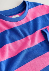 Blå och rosa randig kortärmad t-shirt gjord av texturerat tyg med rund halsringning och en etikett på baksidan.