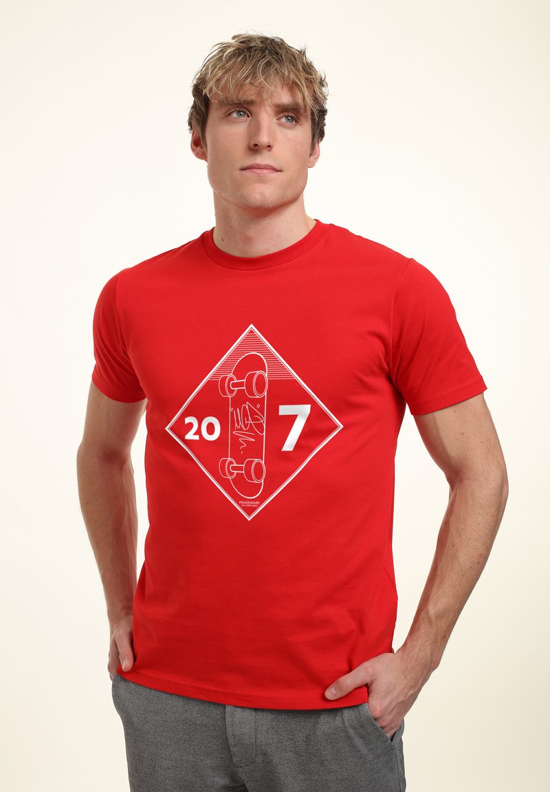 Rød bomulds T-shirt med et hvidt diamantgrafik, der viser tallene "20" og "7" samt en skateboard-illustration i midten.