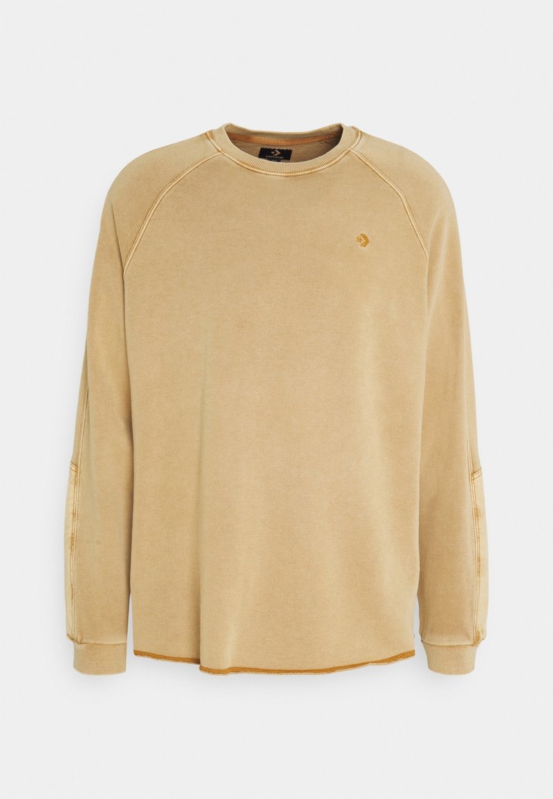 Sweat-shirt beige à manches longues avec col rond, petit logo sur la poitrine et détails de couture visibles sur les manches et l'ourlet.