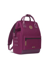 Zaino in tessuto viola con doppi manici superiori, spallacci regolabili, tasca frontale con zip, finitura testurizzata e un'etichetta con logo sulla parte anteriore.