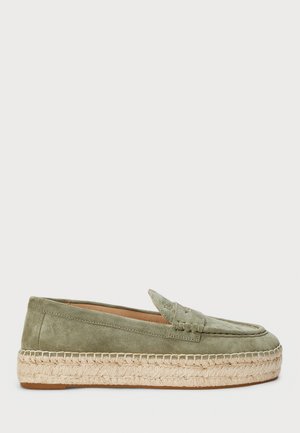 Mocassins en suede vert avec une semelle en jute tissée. Le design classique présente une couture frontale et un détail de surpiqûre. Forme élancée et texture douce.