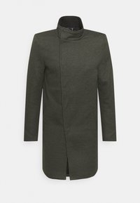 Manteau vert foncé avec un col montant, des manches longues et une coupe droite. Dispose d'une fermeture éclair cachée et de boutons-pression. Tissu texturé.