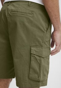 Shorts cargo vert olive en mélange de coton, dotés de poches latérales, d'une poche arrière et de détails cousus.