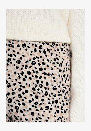 Fitted pants in a beige fabric featuring a black and brown leopard print. Includes a visible metal button and stitching detail.