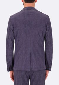 Giacca di abito a righe navy con colletto a doppio petto, spacco singolo sul retro, polsini con bottone e finitura in tessuto testurizzato.