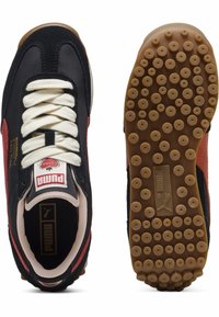 Czarno-czerwone sneakersy z teksturowanego zamszu i siateczki, białymi sznurowadłami, logo na języku oraz gumową podeszwą z okrągłymi wzorami.