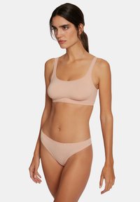Lichtroze beha en bijpassende bikini ondergoed; zachte stof, naadloos ontwerp, brede schouderbanden en een lage tailleband.