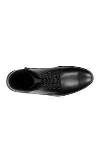 Scarpa in pelle nera con punta arrotondata, design con lacci e cerniera laterale. Texture liscia con minimi dettagli e suola piatta.