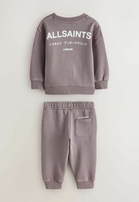 Pelēks kokvilnas sporta krekls un bikses komplekts ar ribotu apaļu kakla izgriezumu, elastīgu jostu un baltu printētu tekstu "ALLSAINTS" abos gabalos.