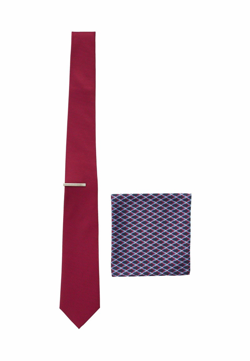 Red textured tie with a silver tie bar beside a navy pocket square featuring a red and white diamond pattern.