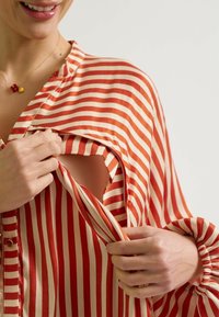 Rood en crèmekleurig gestreepte blouse met een kraaghalslijn, knoopsluiting aan de voorkant en een uitsnede. Zachte, gladde stof met gathered mouwen.