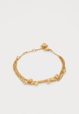 Bracelet en ton doré avec plusieurs chaînes superposées, orné de perles rondes et ovales, ainsi que de petits cristaux transparents pour le détail.