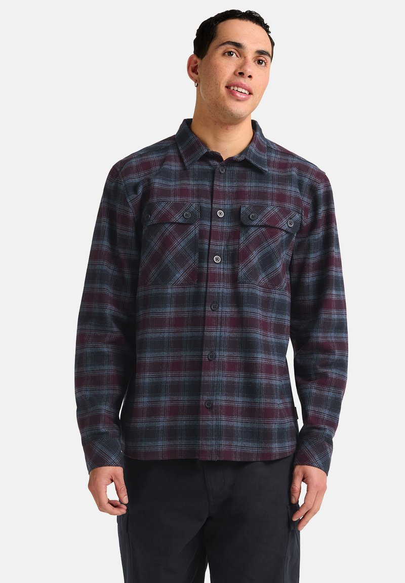 Chemise en flanelle à carreaux dans les tons bordeaux et marine, avec deux poches poitrine, fermeture à boutons et manches longues au fit décontracté.