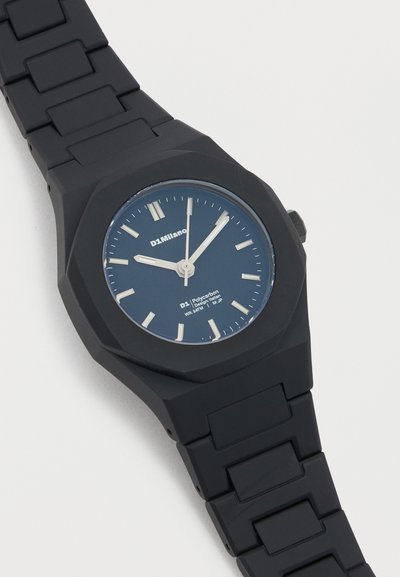 Μαύρο ρολόι χειρός D1 Milano με μπλε καντράν, λευκούς δείκτες ώρας και λουράκι από συνδεδεμένο σιλικόνη, δείχνοντας ώρα 10:10:59.