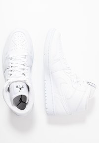 Zapatillas altas blancas de piel, con puntera perforada, cordones planos, suela de goma y un acento de logo en la lengüeta.