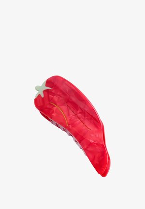 Red plastic hair clip shaped like a chili pepper, featuring a glossy finish, white accents, and a textured surface for grip.