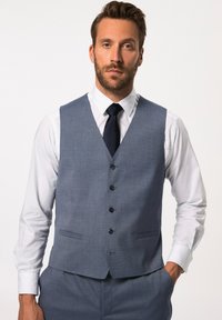 Gilet grigio con un tessuto testurizzato, cinque bottoni e due tasche anteriori, abbinato a una camicia bianca e una cravatta blu navy. Vestibilità su misura, design formale.