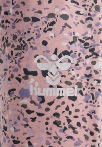 Flerfärgade rosa knälånga leggings med ett prickigt mönster i svart och lavendel, med en framträdande vit "hummel"-logotyp.