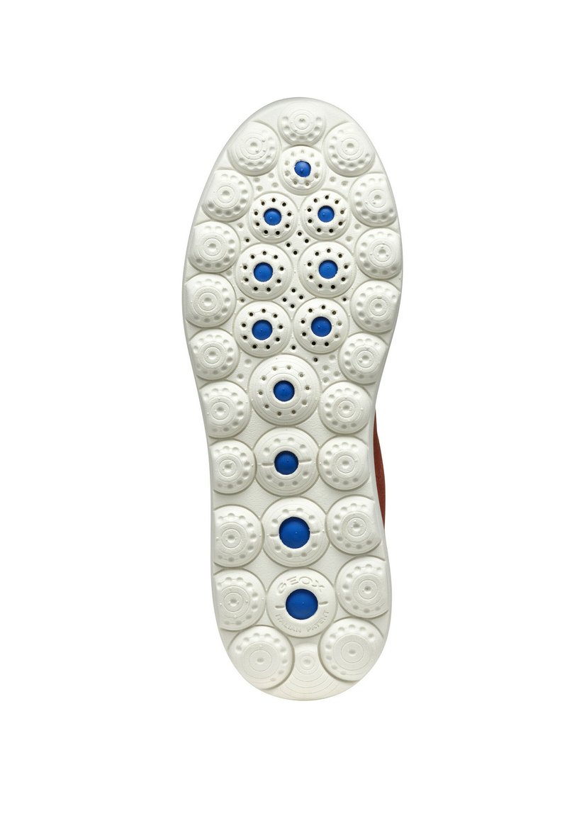 Biała gumowa podeszwa z okrągłym wzorem bieżnika; posiada niebieskie akcenty w centrum niektórych okręgów; teksturowana dla lepszej przyczepności.