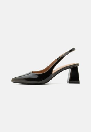 Chaussure slingback en cuir verni noir avec bout pointu et talon bloc sur fond blanc.