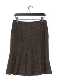 Tmavě hnědá tweedová sukně s rozšířeným zakončením a sklady. Disponuje skrytým zipem a visí na černém plastovém ramínku.