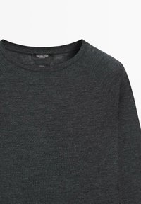 Tmavě šedý svetr s kulatým výstřihem a raglánovými rukávy, vyrobený z měkké texturované látky. Štítek nese nápis „Massimo Dutti“.
