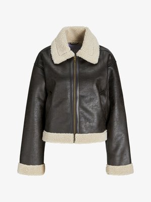 Barna műbőrből készült dzseki krémszínű gyapjúszegéllyel, cipzáras záródással és passzoló mandzsettákkal. Ráadásul rövidített fazonú és textúrázott felületű.