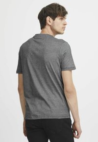 Hall hall lühikeste varrukatega T-särk ümara kaelusega, sileda tekstuuriga ja mugava lõikega, kujutatud tagant neutraalse tausta ees.