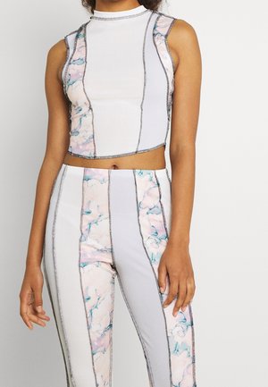 Ærmeløs cropped top og bukser med høj talje med skiftevis lodrette ribstrikkede og lyserødt-blåt marmorerede paneler, der er markeret med mørk syning.