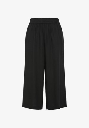 Mustad, laiad püksid elastse vöökohtaga, valmistatud pehmest kangast, laia lõike ja pahkluu pikkusega. Ilma nähtavate kinnitusteta.