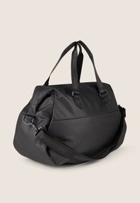 Borsone nero realizzato in tessuto morbido, dotato di doppi manici e di una tracolla regolabile con dettagli brandizzati. Forma curvata.