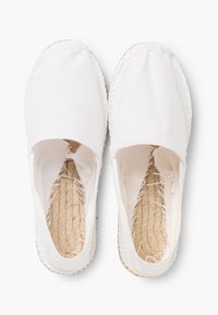 Espadrilles en toile blanche avec un design traditionnel à bout fermé. Présentent une semelle en jute et des bords en textile non finis pour un look décontracté.