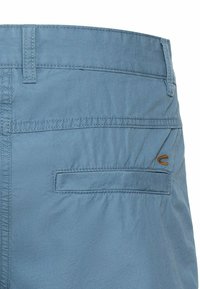 Blauwe shorts met een gladde textuur, voorzien van een achterzak en een klein bruin logo. Gestikte details langs de taille en de rand van de zakken.